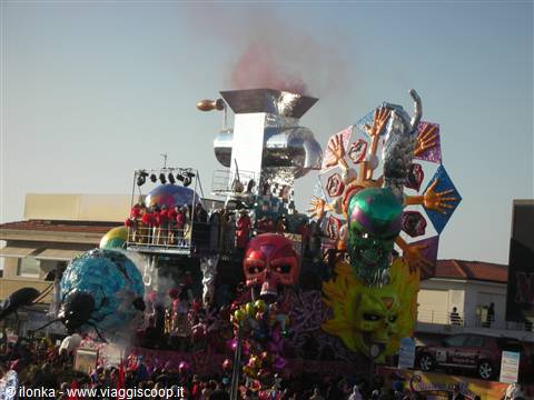 Carnival float with colorful masks, steel structures and smoke over the crowd