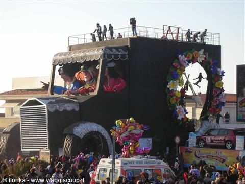 Giant black carnival float with masked riders and crowd, Viareggio parade