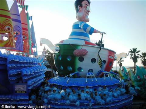 Viareggio carnival float: giant papier-mâché figure on a polka-dot bowl, costumed revelers