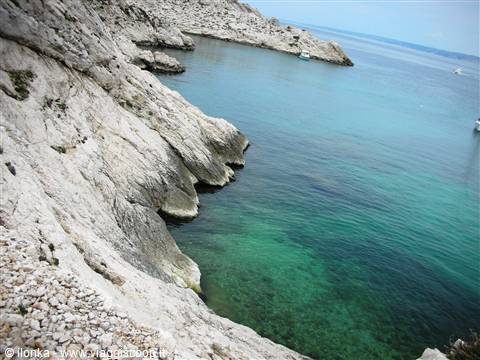 White limestone cliffs and turquoise water in a calanque, boats anchored