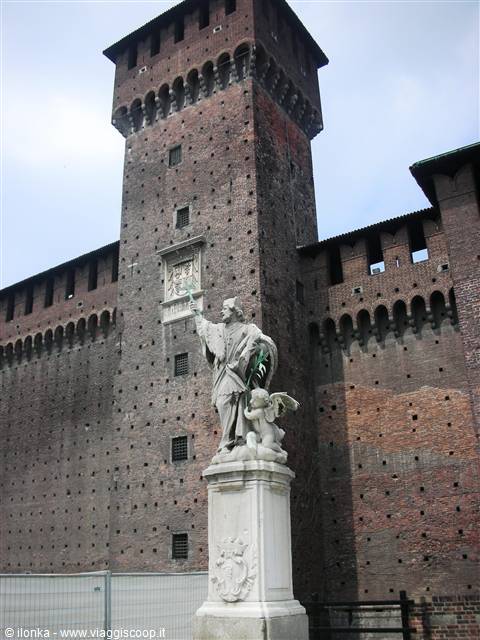 Marble statue in front of the brick tower of Castello Sforzesco in Milan