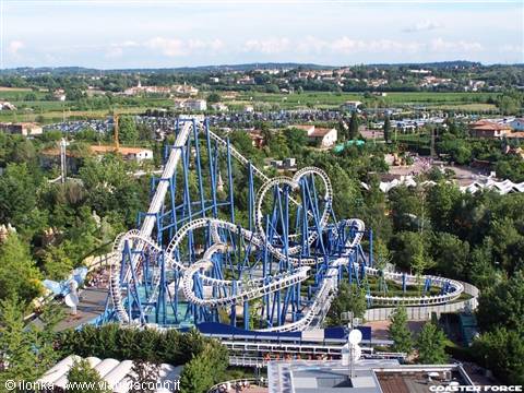 Blue Tornado roller coaster at Gardaland, steel tracks among green trees
