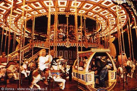 Children riding wooden horses on an illuminated old carousel