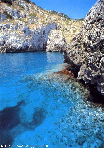 Clear turquoise water between white limestone rocks, boulder on the right