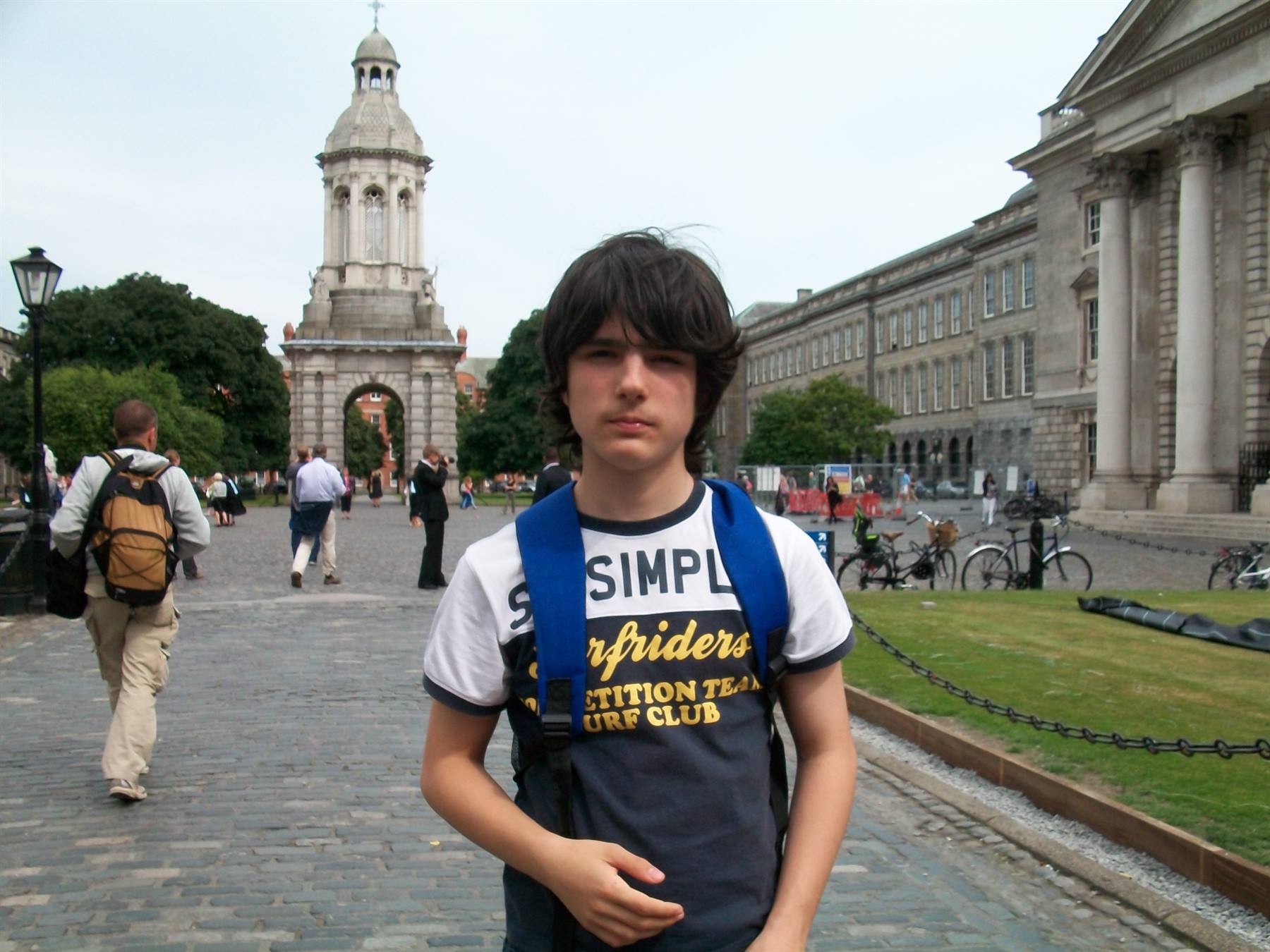 Boy with blue backpack in front of the Trinity College Dublin campanile