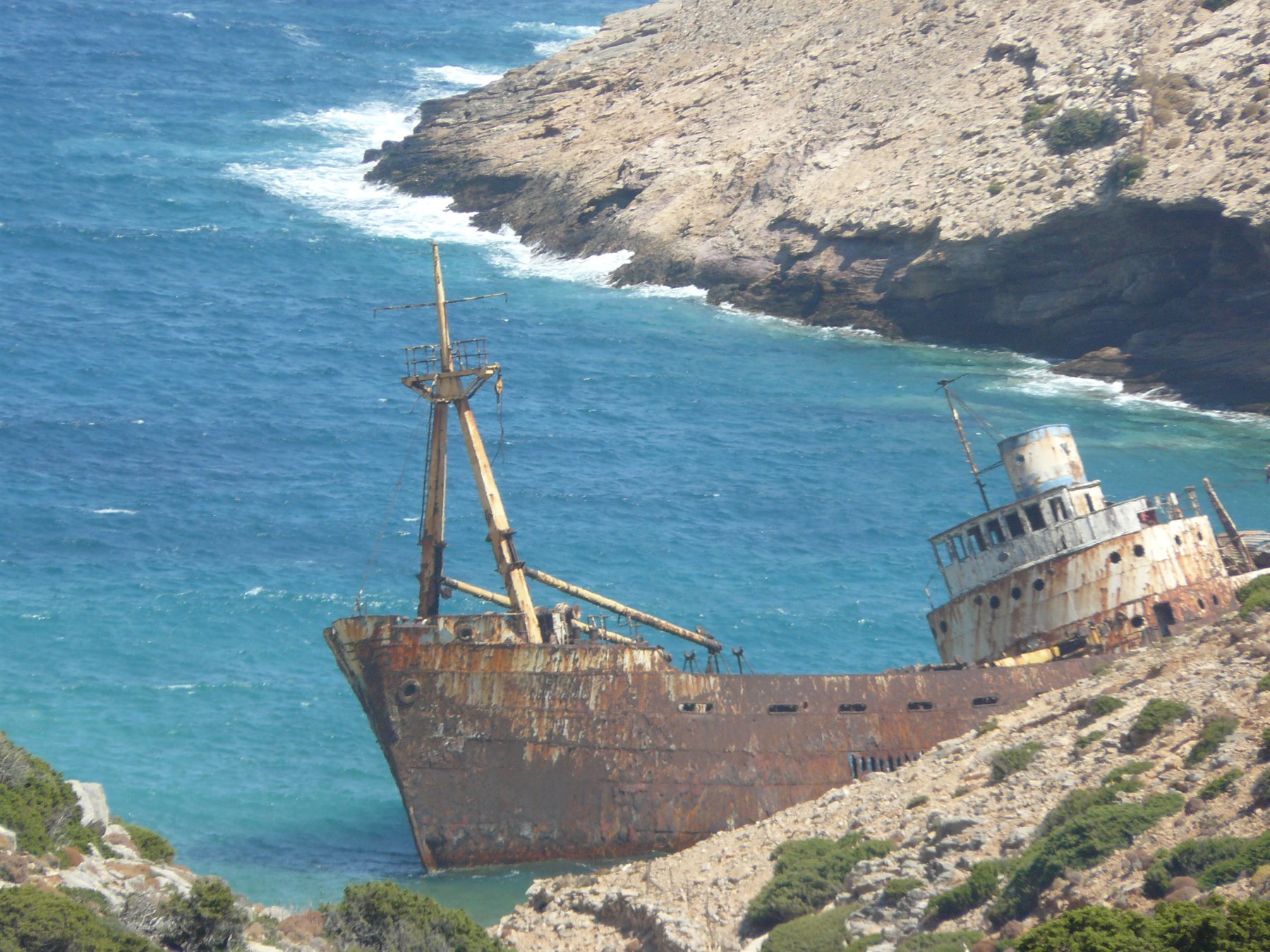 Nave relitto arrugginita incagliata sulla costa rocciosa di Amorgos