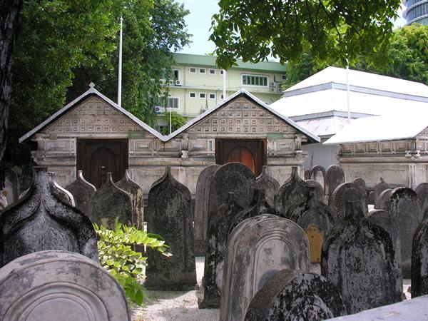 Coral stone tombstones and carved mausoleums at a cemetery in Malé