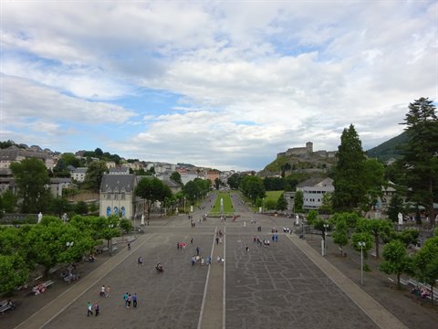 Lourdes esplanade in front of the sanctuaries, visitors strolling among the trees