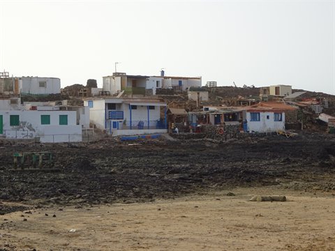 White houses with blue trim on dark sand beach, Fuerteventura