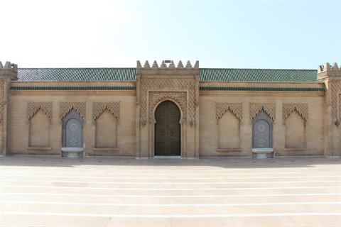 Facciata in pietra con portale ad arco e tetti verdi, Rabat