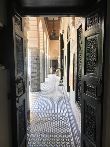 Porta intagliata del Palais Bahia aperta sul corridoio con zellige