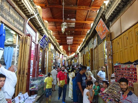 Visitatori e negozianti affollano il souk coperto in legno di Fes
