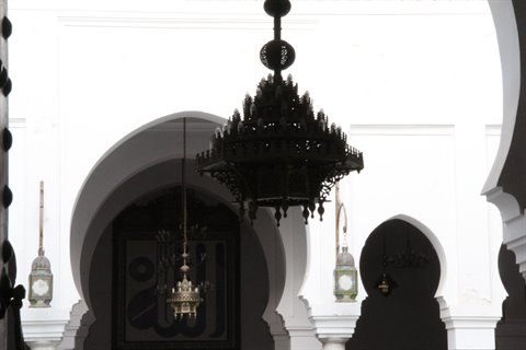 Lampadario in metallo battuto dentro gli archi bianchi del mausoleo