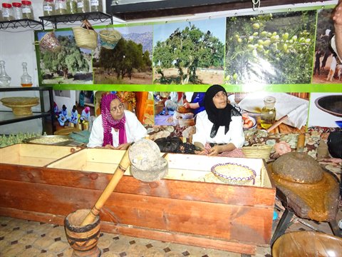 Donne in una cooperativa di argan con macine in legno e pietra