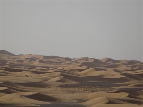 Golden sand dunes at Merzouga, grey haze above the ridges