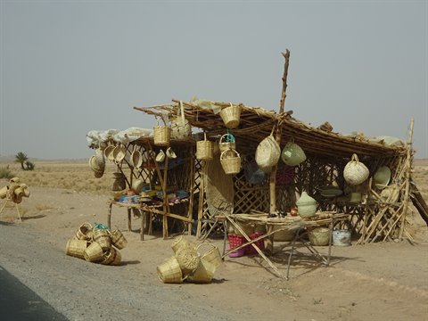 Chiosco di canne con cesti intrecciati appesi lungo la strada desertica