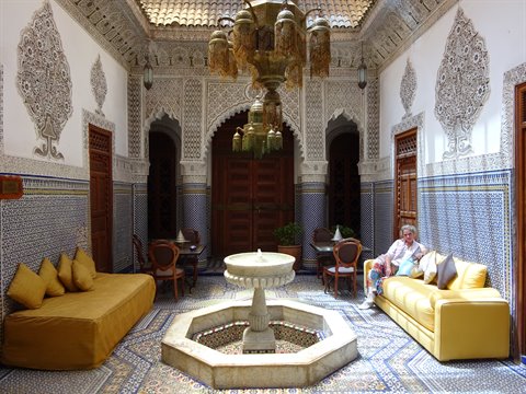 Riad a Fes: zellige, fontana di marmo, divani gialli e lampade