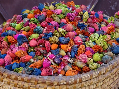 Cesto di paglia traboccante di fiori e boccioli essiccati colorati, souk di Marrakech