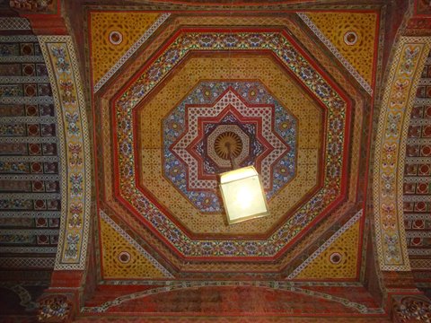 Soffitto ligneo dipinto con motivi geometrici e lanterna illuminata, Marrakech