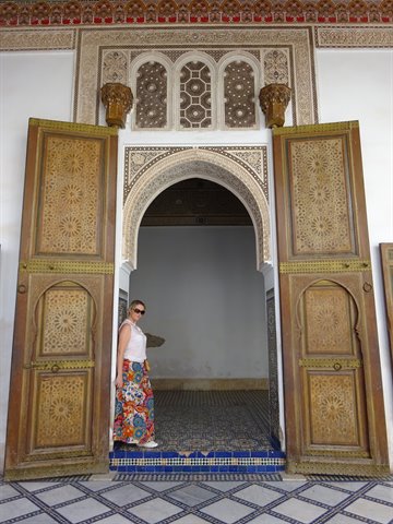Turista tra le porte intarsiate del Palazzo della Bahia a Marrakech