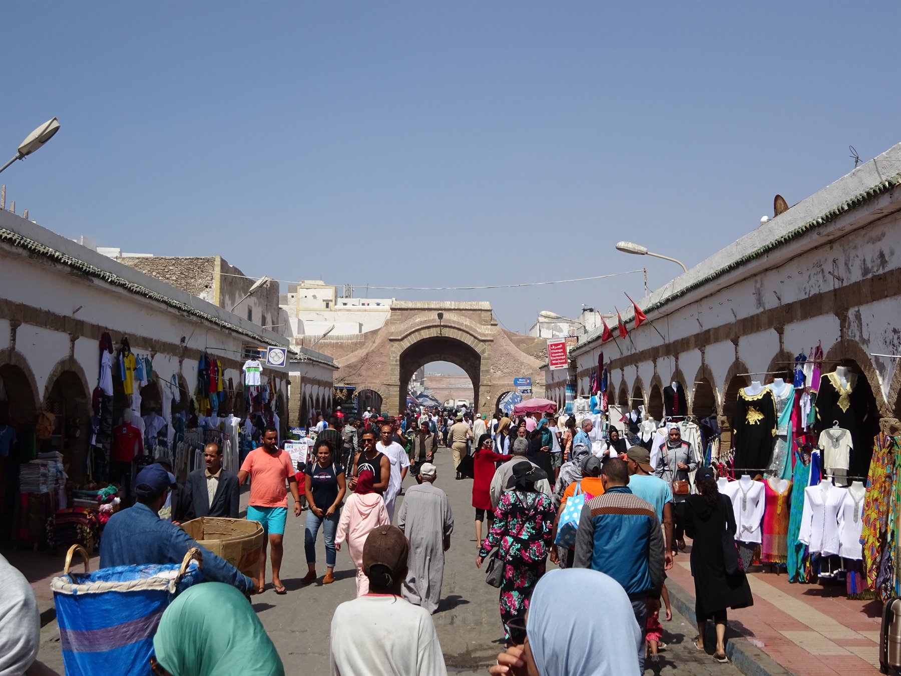 Essaouira market crowds browsing stalls under arcades near the historic gate