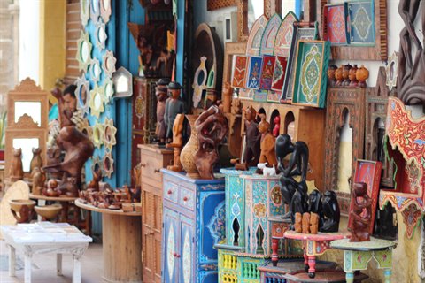 Craft stall with carved painted wooden goods in the Essaouira souk