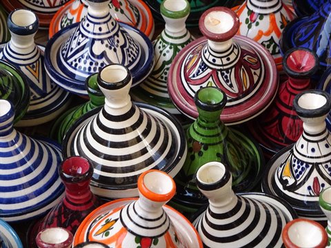 Colorful painted ceramic tagines for sale in a Marrakech souk