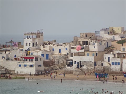 Fishing village with whitewashed houses and blue boats on the beach, Tifnit
