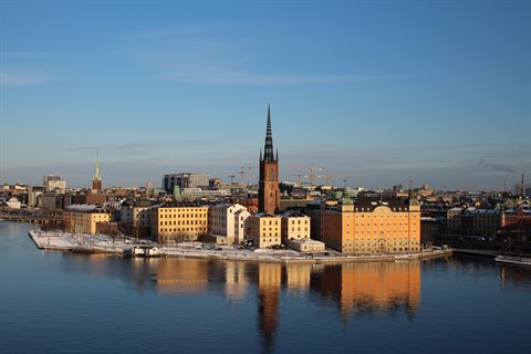 Riddarholmen in Stockholm: church spire and ochre buildings reflected in calm winter water