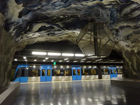 Train stopped at T-Centralen metro station, sculpted rock ceiling, artificial lights