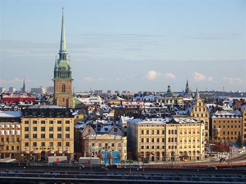 Snowy rooftops of Stockholm with the green spire of Klara Church