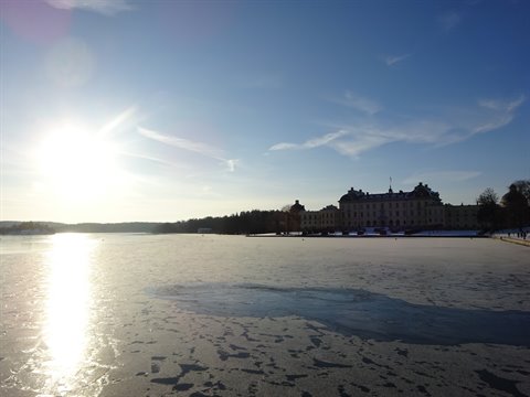 Frozen lake in front of Drottningholm Palace under bright sun