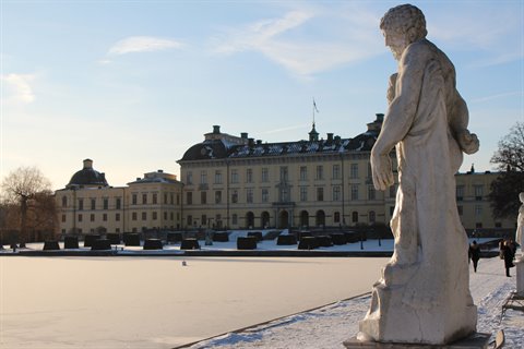 Marble statue in front of snow-covered Drottningholm Palace, Stockholm