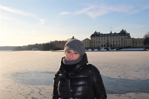 Woman in winter clothes by Drottningholm Palace across the frozen lake, Stockholm