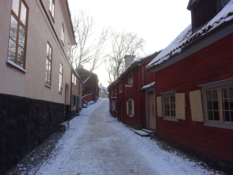 Snowy alley between red wooden houses at Skansen, Stockholm