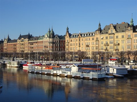 Boats moored along Strandvägen in Stockholm, nineteenth-century façades under clear sky