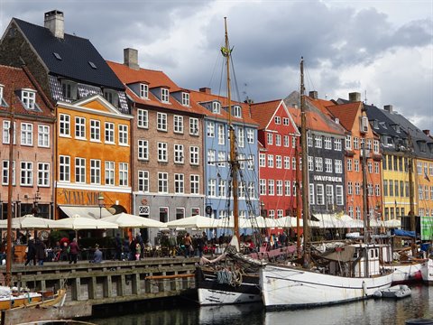 Nyhavn, Copenhagen: colorful townhouses, moored sailing ships and umbrellas along the canal