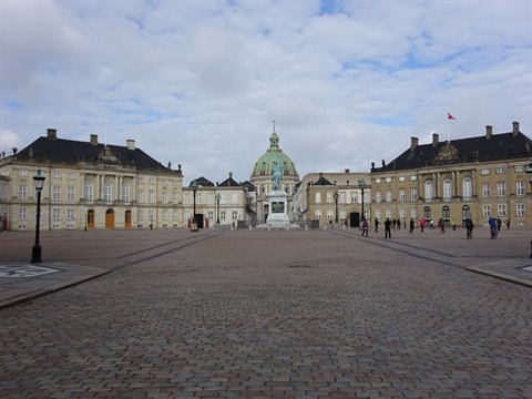 Cobbled square at Amalienborg in Copenhagen with equestrian statue and green dome