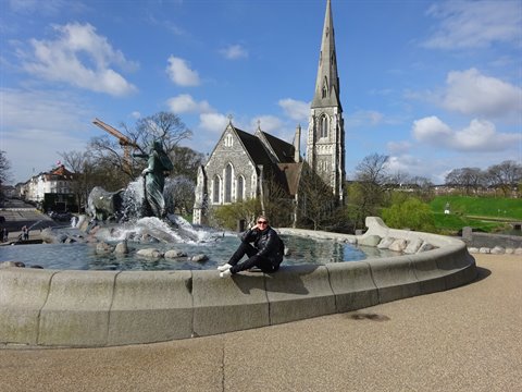 Woman sitting on the Gefion Fountain in front of St Alban's Church, Copenhagen