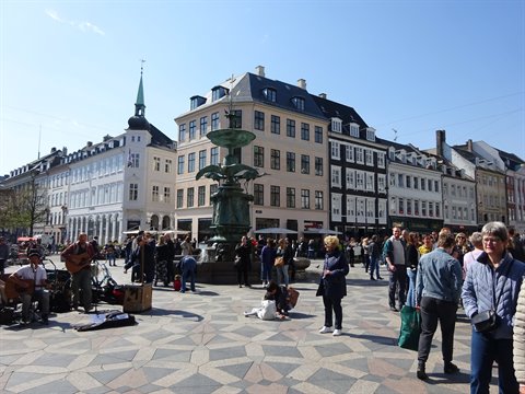 Street musicians play beside the Caritas Fountain on Gammeltorv square, Copenhagen