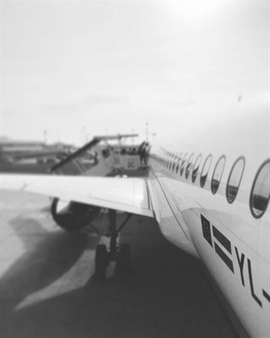 White fuselage with windows and boarding stairs, black and white