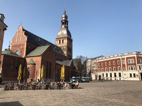Red brick Lutheran church and outdoor café on Riga's cobblestone square