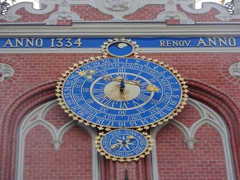 Blue and golden astronomical clock on the brick facade of the House of the Blackheads, Riga