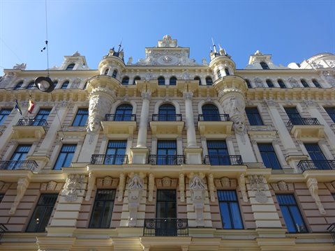 Art Nouveau building in Riga with statues, wrought-iron balconies and blue sky