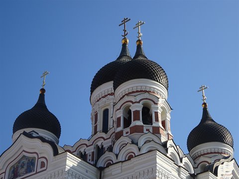 Black onion domes of Alexander Nevsky Orthodox Cathedral in Tallinn against blue sky