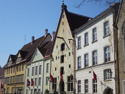 Medieval merchant houses in Tallinn's old town, colorful facades under blue sky