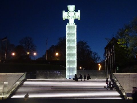 The glass Cross of Liberty lit up at night on Freedom Square, Tallinn