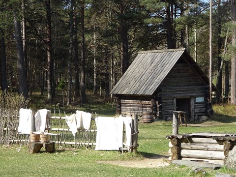 Laundry drying on a wooden fence beside a log cabin, Seurasaari