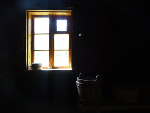 Wooden bucket in a dark cabin, light through the small window
