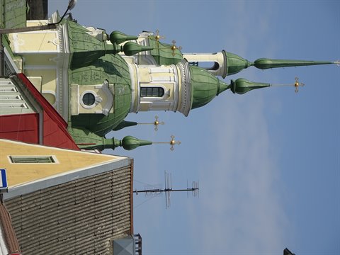 green onion domes with golden crosses above rooftops, blue sky